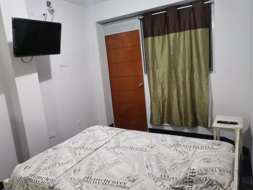 普卡尔帕Hotel JK的一间卧室配有一张床和一台平面电视