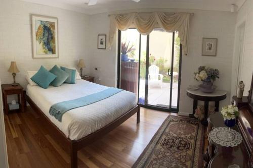拜伦湾Beautiful 2Bdr House with Pool的一间卧室配有一张带蓝色枕头的大床
