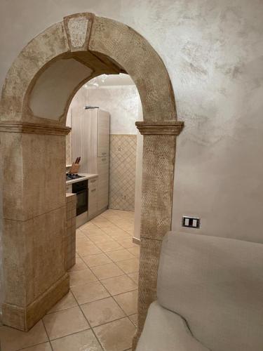 CeccanoAppartamento Marchesini的厨房内的拱门,配有炉灶和冰箱