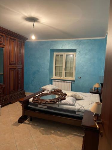 CeccanoAppartamento Marchesini的一间卧室设有一张蓝色墙壁的大床