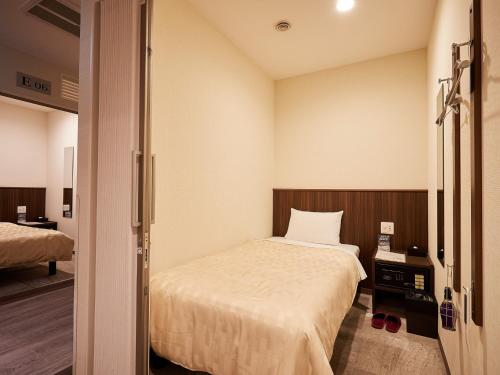 那霸Grand Cabin Hotel Naha Oroku for Women / Vacation STAY 62324的一间小房间,配有床,一间房间