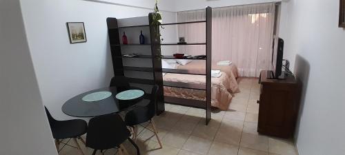布宜诺斯艾利斯Súper Luminoso en Caballito的小房间设有一张床、一张桌子和椅子