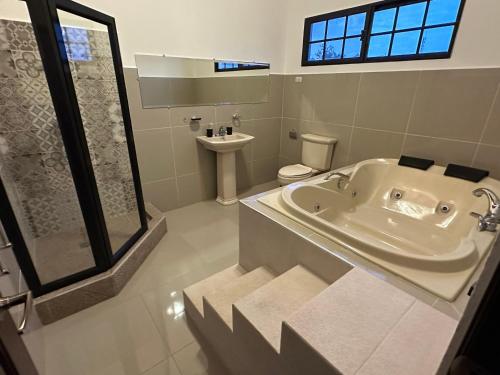 科马亚瓜Helechos Hotel的带浴缸、卫生间和盥洗盆的浴室