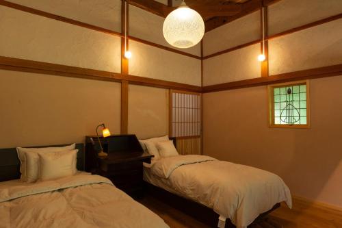 安来市Ryokuinsansou-bettei - Vacation STAY 48641v的客房设有两张床、一台电视和一扇窗户。