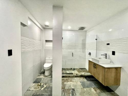曼努埃尔安东尼奥Pura Natura Lodge Manuel Antonio的白色的浴室设有水槽和卫生间。