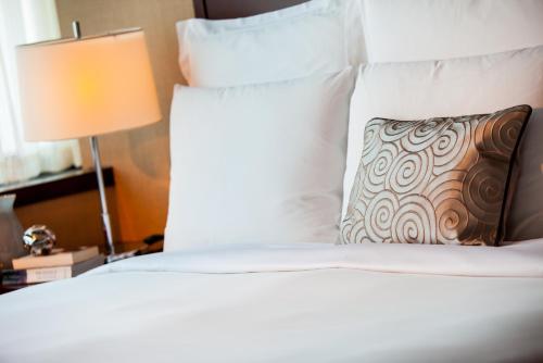 上海上海龙之梦万丽酒店的配有枕头和灯的白色床