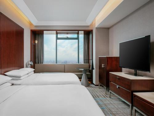 上海上海龙之梦万丽酒店的酒店客房设有两张床和一台平面电视。