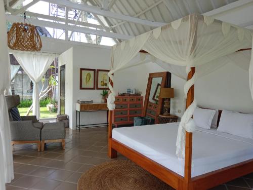马塔兰Le Kekeri Villas Collection的一间卧室配有一张带天蓬的床
