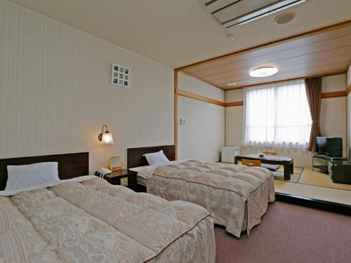 会津若松芦牧王子酒店的酒店客房设有两张床和电视。