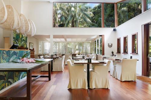 豪勋爵岛阿拉吉拉度假山林小屋的餐厅设有桌椅和大窗户。