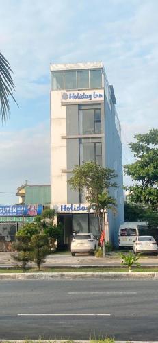 岘港Holiday Inn Hotel的前面有停车位的建筑