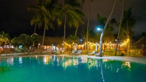 美奈MUINE SUN & SEA BEACH ( BOUTIQUE RESORT & GLAMPING)的棕榈树和灯光的夜间游泳池