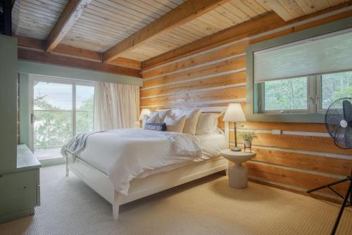 帕里桑德Luxury Waterfront Cottage的卧室配有白色的床和木墙