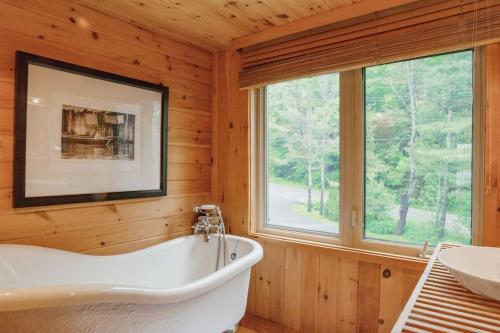 帕里桑德Luxury Waterfront Cottage的带浴缸的木制浴室设有窗户