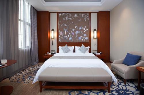石家庄石家庄云瑞酒店（正定新区）的卧室配有一张白色的大床和一张沙发。