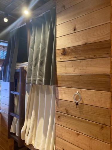北谷町Surfer's Cafe& Hostel的木墙客房的一张床位