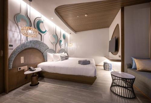 卡塔海滩Metadee Concept Hotel的一间酒店客房,配有一张床和一台电视