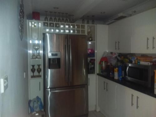 库伯佩迪Opal Art House的厨房配有不锈钢冰箱和白色橱柜