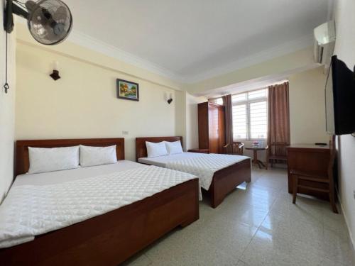 格卢市社Châu Giang Hotel Cửa Lò的酒店客房设有两张床和电视。