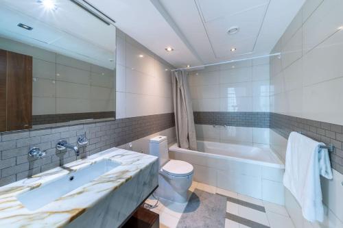 迪拜Heart of the Marina - 1 BR apartment的带浴缸、卫生间和盥洗盆的浴室