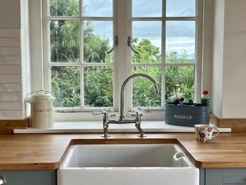 莱姆里吉斯Cobblers Lodge的厨房设有水槽和窗户。