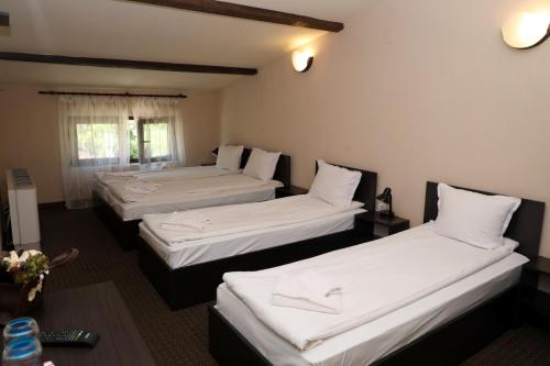 希普卡Опълченец的配有白色床单的酒店客房内的两张床