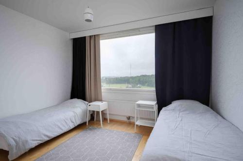 图尔库Saris 4 bedroom apartment with view的一间卧室设有两张床和窗户。