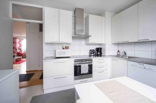 图尔库Saris 4 bedroom apartment with view的白色的厨房配有白色的橱柜和微波炉