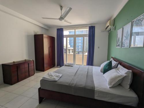 科伦坡帕尔米拉住宅酒店的一间卧室设有一张大床和一个大窗户