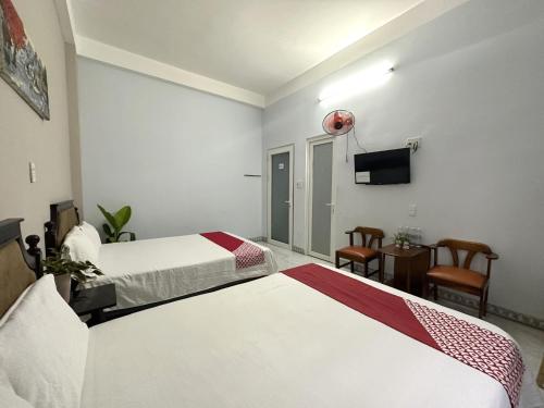 岘港OYO 1187 Suoi Da Motel的酒店客房设有两张床和一台平面电视。