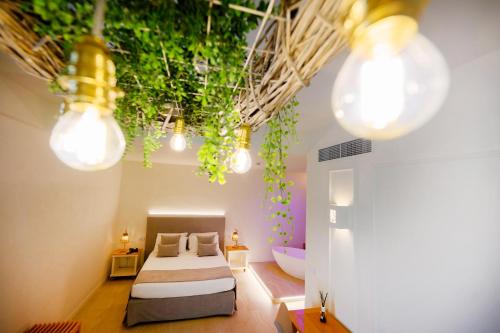 曼弗雷多尼亚曼弗雷迪瑞金酒店的一间卧室配有床,还有一些灯和植物