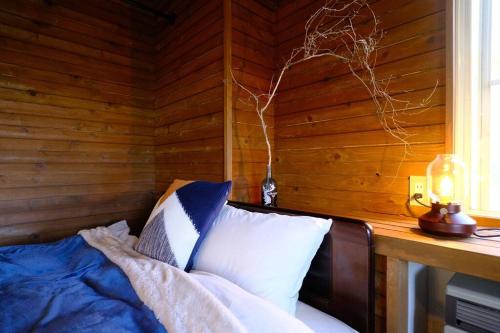 富士河口湖ヒウチバコ的一间卧室配有一张木墙床