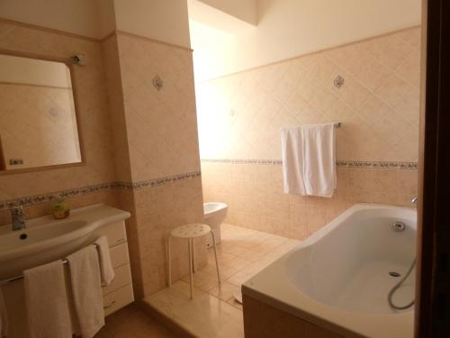 陶尔米纳Villa Magnolia B&B的带浴缸、盥洗盆和卫生间的浴室