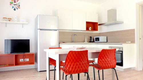 加尔多内-里维耶拉Casa di Elisa的厨房配有白色的桌子和红色的椅子