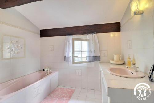 阿尔勒Villa Mariella的一间带水槽和浴缸的浴室以及窗户。