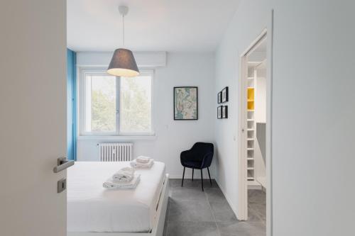 米兰Easylife - Rifugio a 2 min dall'Ospedale Niguarda的卧室配有床、椅子和窗户。