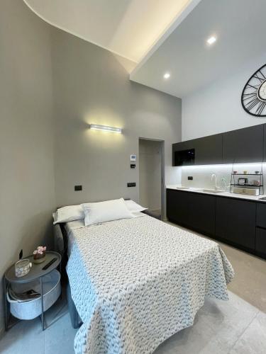 科莫Civico29 appartamento bilocale的卧室配有一张床,墙上挂着一个钟