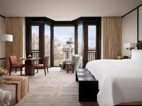 伦敦The Peninsula London的酒店客房带一张床、一张桌子和椅子