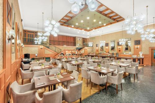 杰尔Danubius Hotel Raba的用餐室配有桌椅和吊灯。