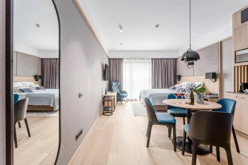 格但斯克Deo Plaza Old Town Gdańsk - Praia Apartaments的酒店客房带两张床和一张桌子以及椅子。