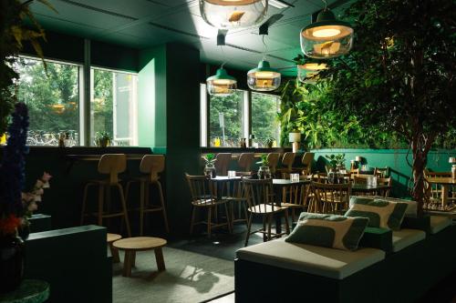 阿姆斯特丹Qbic Amsterdam WTC的一间带桌椅的餐厅和一间酒吧