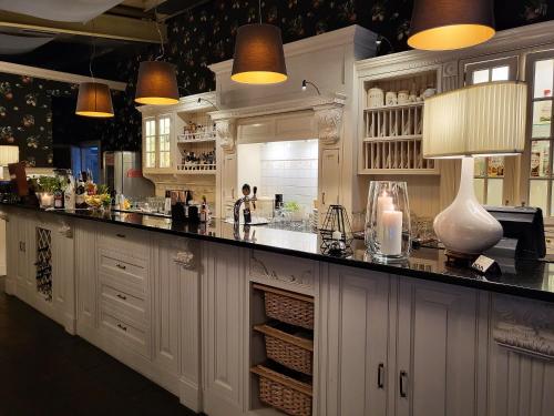 杰隆卡皮特索克酒店的厨房配有白色橱柜和黑色台面