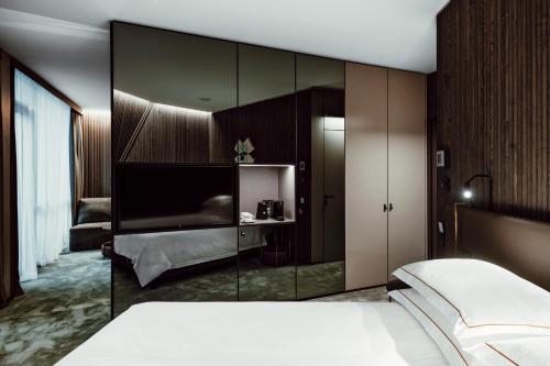 德鲁斯基宁凯Amberton Green SPA Druskininkai的一间卧室设有一张床和一个大型玻璃墙