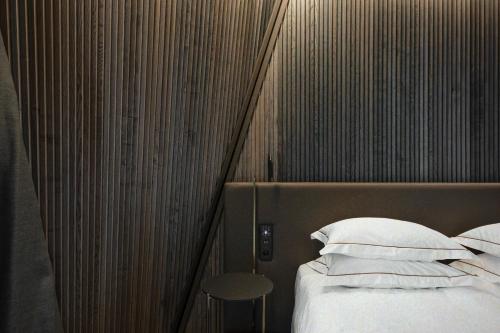 德鲁斯基宁凯Mana Sleep & Spa的一间卧室配有带白色枕头和凳子的床