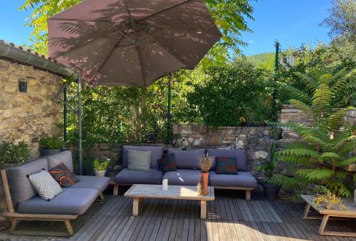 奥拉尔盖MAISON ST LAURENT的一个带蓝色沙发和遮阳伞的庭院