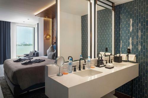 坎昆Canopy By Hilton Cancun La Isla的一间带水槽和大镜子的浴室