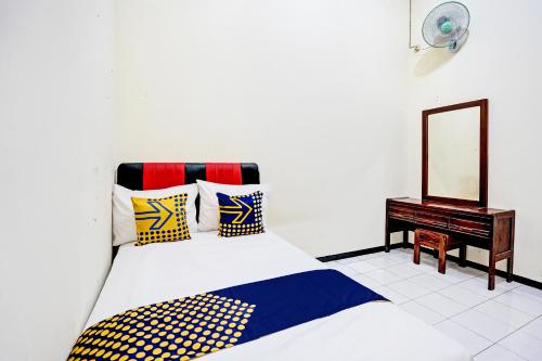 TubanOYO Life 92785 Wisma Trubus Syariah的一间卧室配有一张床、镜子和一张桌子
