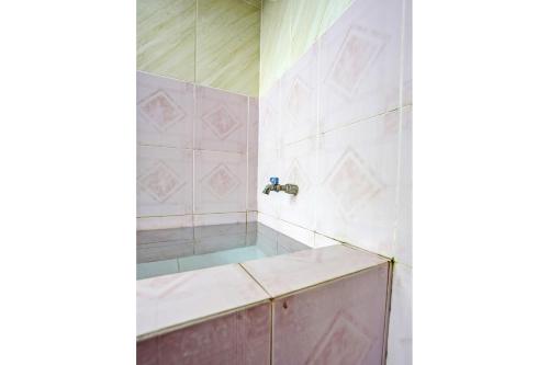 TubanOYO Life 92785 Wisma Trubus Syariah的带浴缸和盥洗盆的淋浴浴室