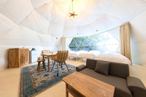 HasunumaInnocence Resort -in Chiba Resol-的一间卧室设有圆顶天花板、一张沙发和一张桌子