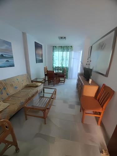 马塔拉斯卡尼亚斯bonito apartamento en caño guerrero, Matalascañas的客厅配有沙发和椅子